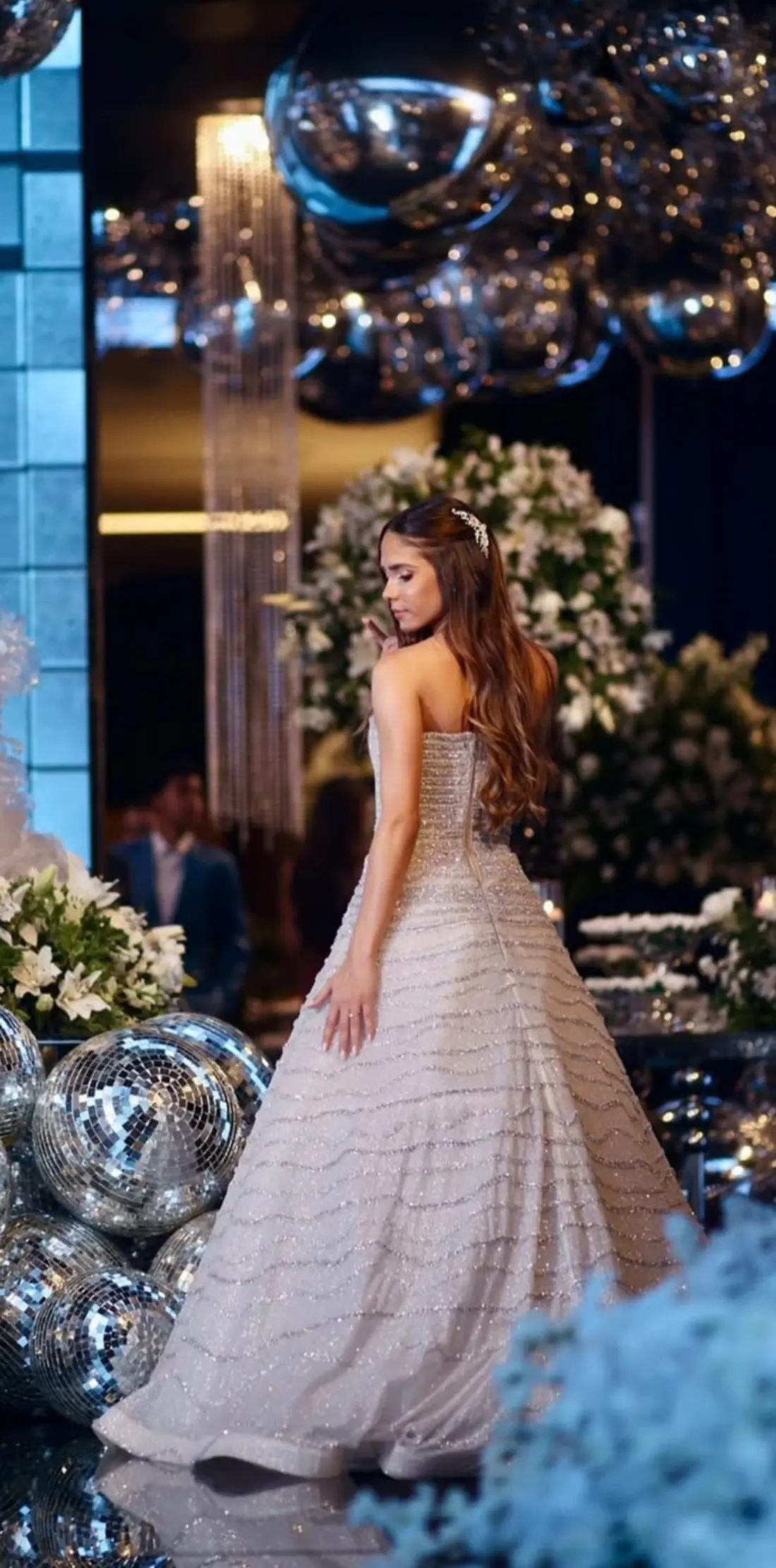 Debutante com vestido paetê champagne em festa iluminada